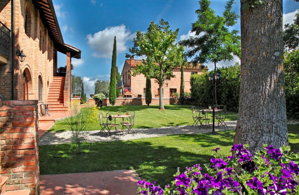 a garden with tables and chairs and flowers at Borgo Tre Rose in Valiano