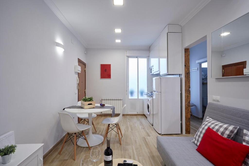マドリードにあるLEEWAYS LOFT in VALENCIAの白いアパートメントで、テーブル、冷蔵庫が備わります。