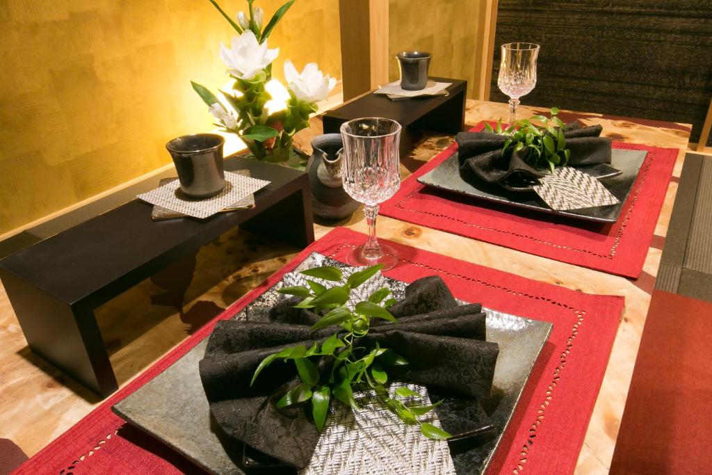 a table with two red and black plates and glasses at Hosta Toji San in Kyoto