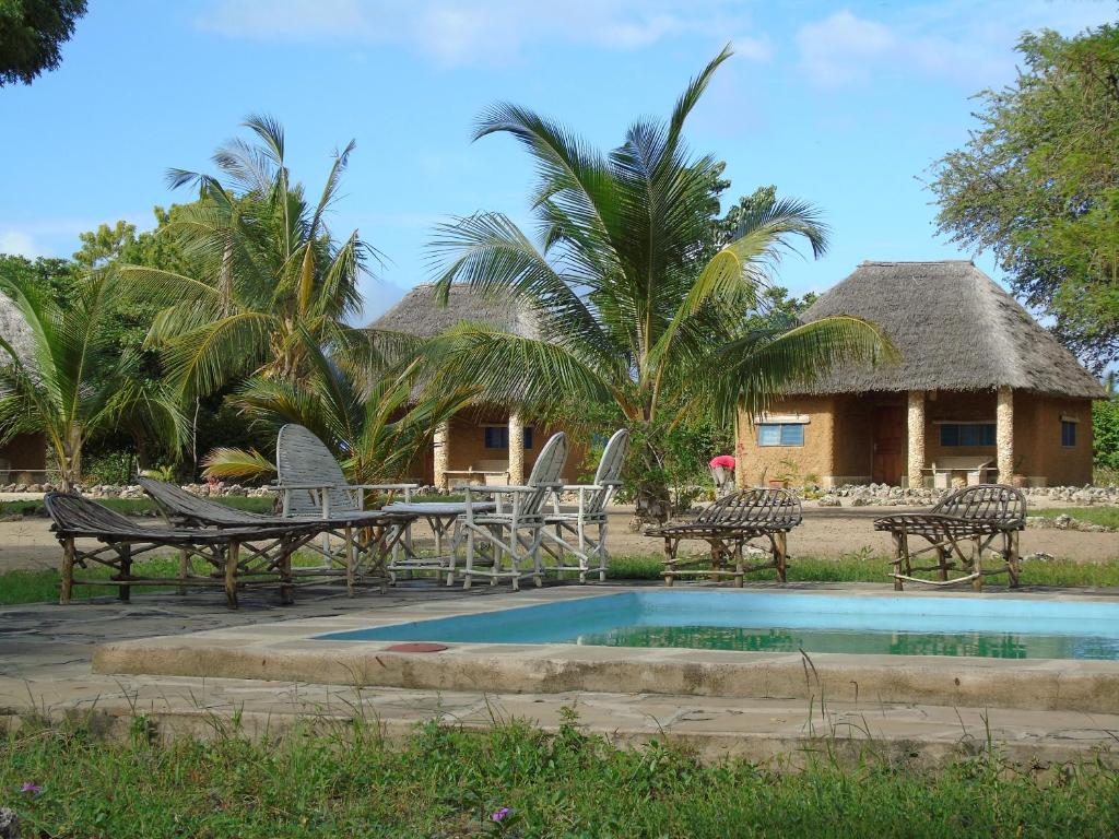 a resort with a table and chairs next to a pool at ShambaZuri in Gede