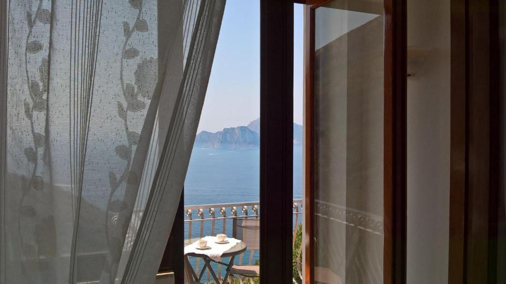 a room with a view of the ocean from a window at Acquamarina Accommodation in Massa Lubrense