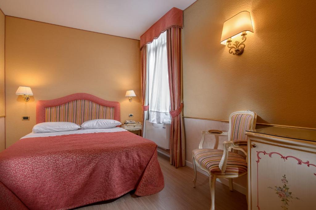a bedroom with a bed with a red blanket and a window at Casa Burchielle in Venice