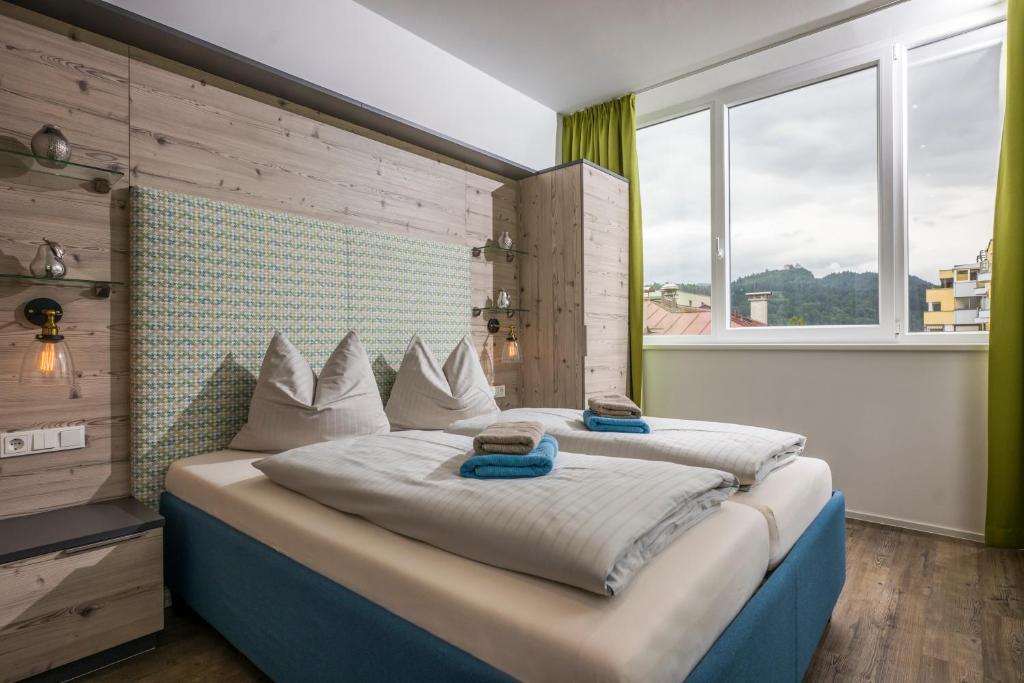 a large bed in a room with a large window at Aparthotel Backstage in Kufstein