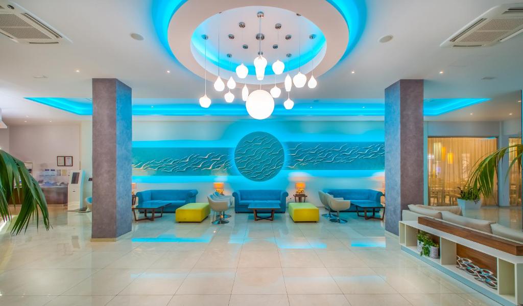 un vestíbulo con una pared azul y una lámpara de araña en Stamatia Hotel en Ayia Napa