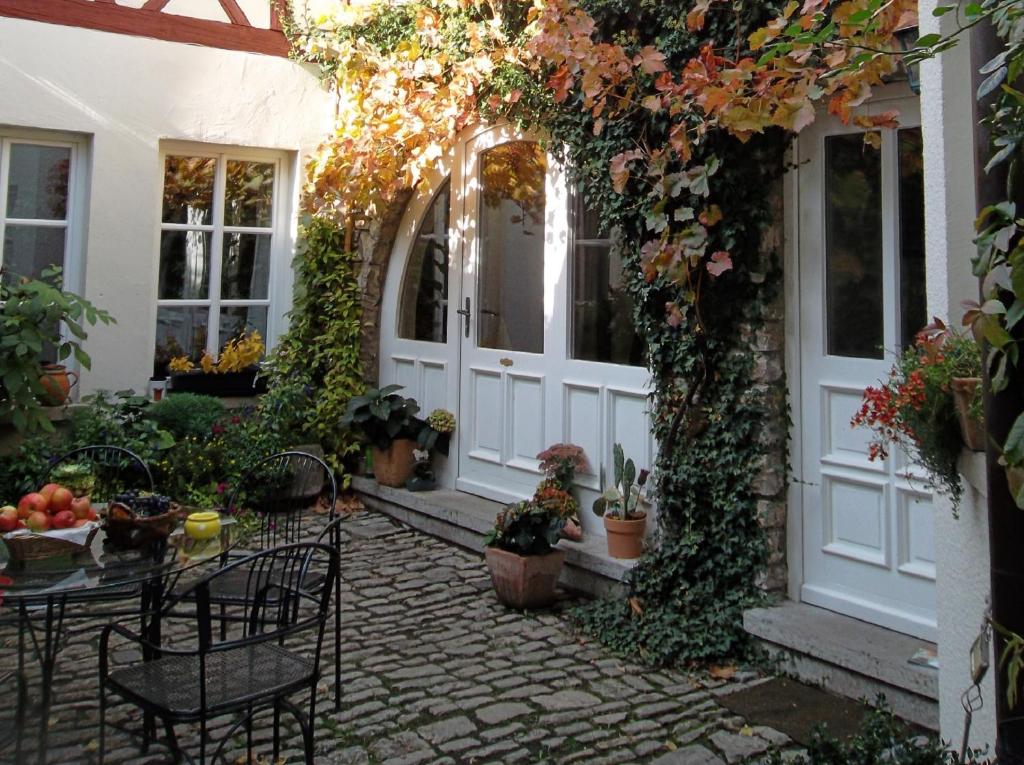 un patio al aire libre con mesa, sillas y plantas en Weingärtner's Hof, en Sommerach