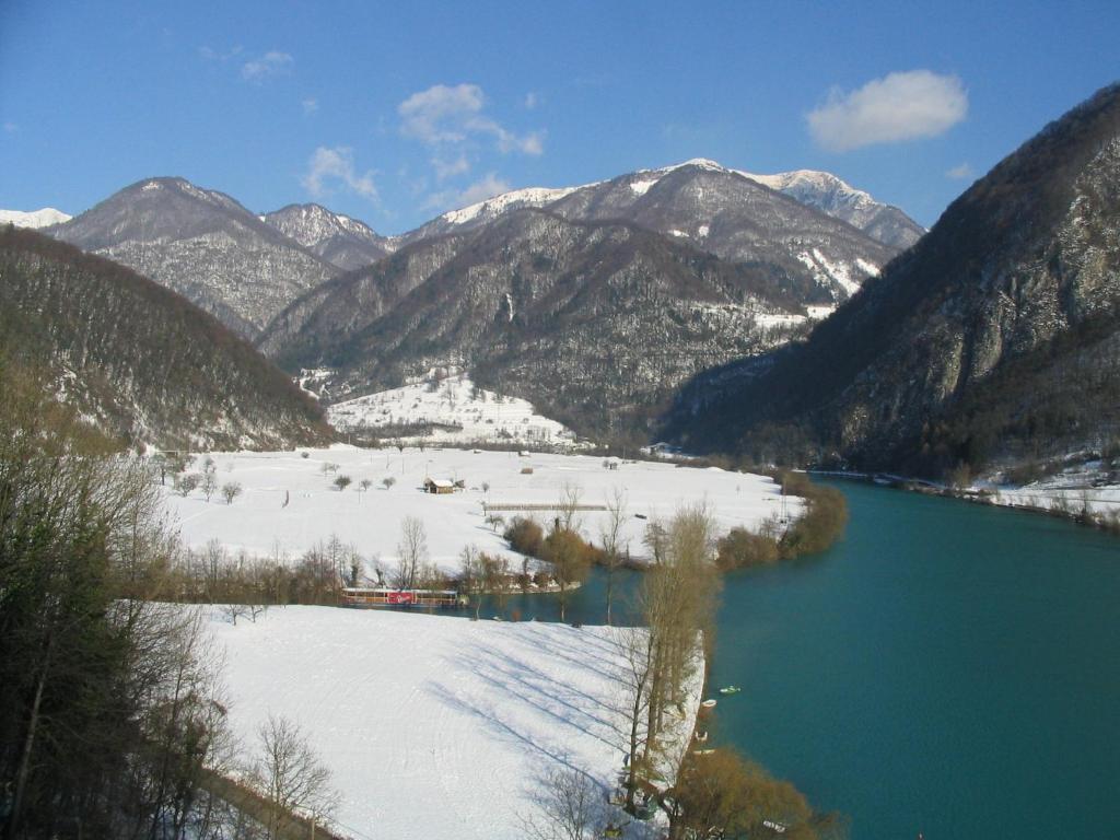 a view of a snow covered mountain range with a lake at Apartments Bobi in Tolmin