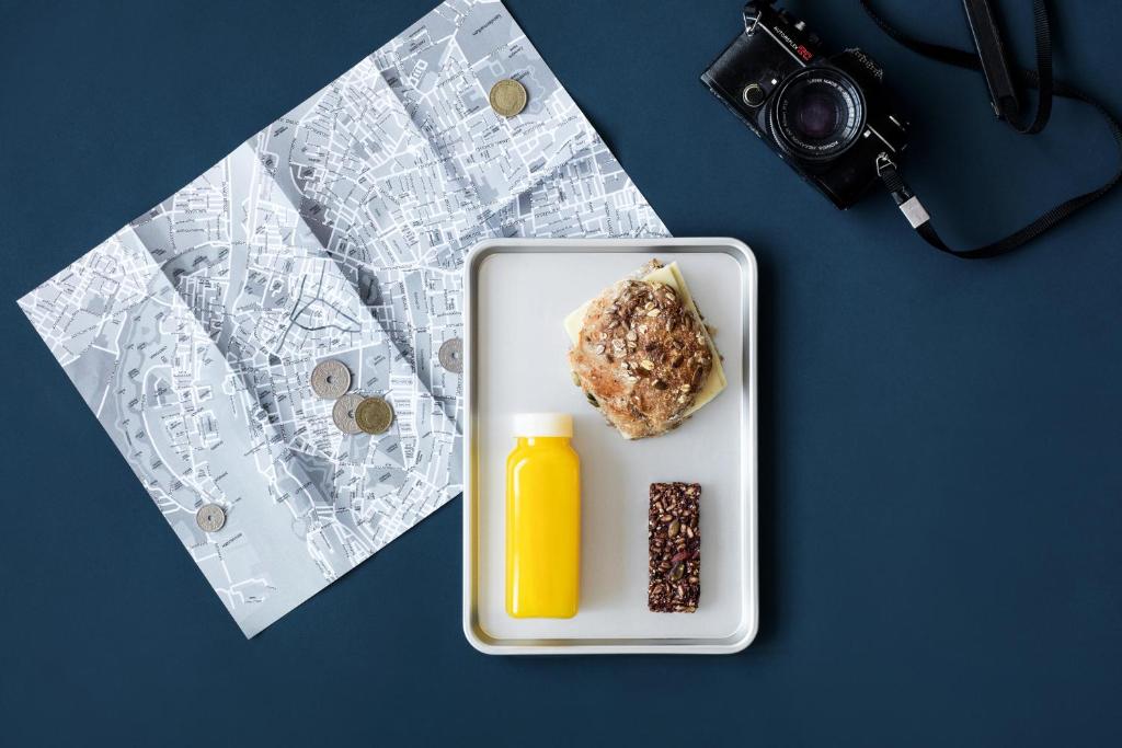 a plate of food and a bottle of orange juice at Steel House Copenhagen in Copenhagen
