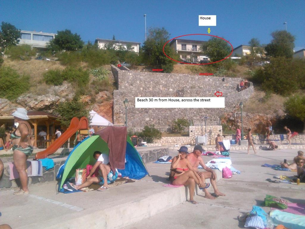 un gruppo di persone sedute in spiaggia di Apartment Denis a Senj