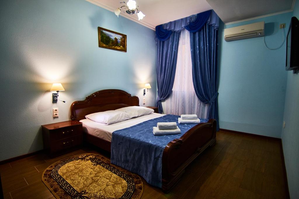 阿德列爾的住宿－大衛酒店，一间卧室配有床和蓝色窗帘的窗户