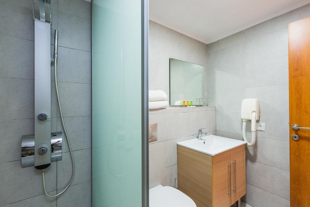 a bathroom with a shower and a toilet and a sink at Xidas Garden in Bali