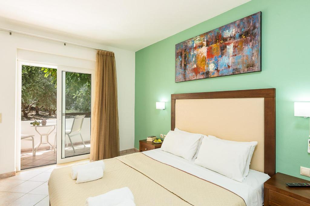 a bedroom with a large bed and a balcony at Xidas Garden in Bali