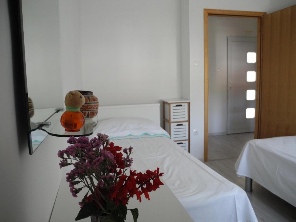 a bedroom with a bed with a vase of flowers at Villa Ines in Jezera