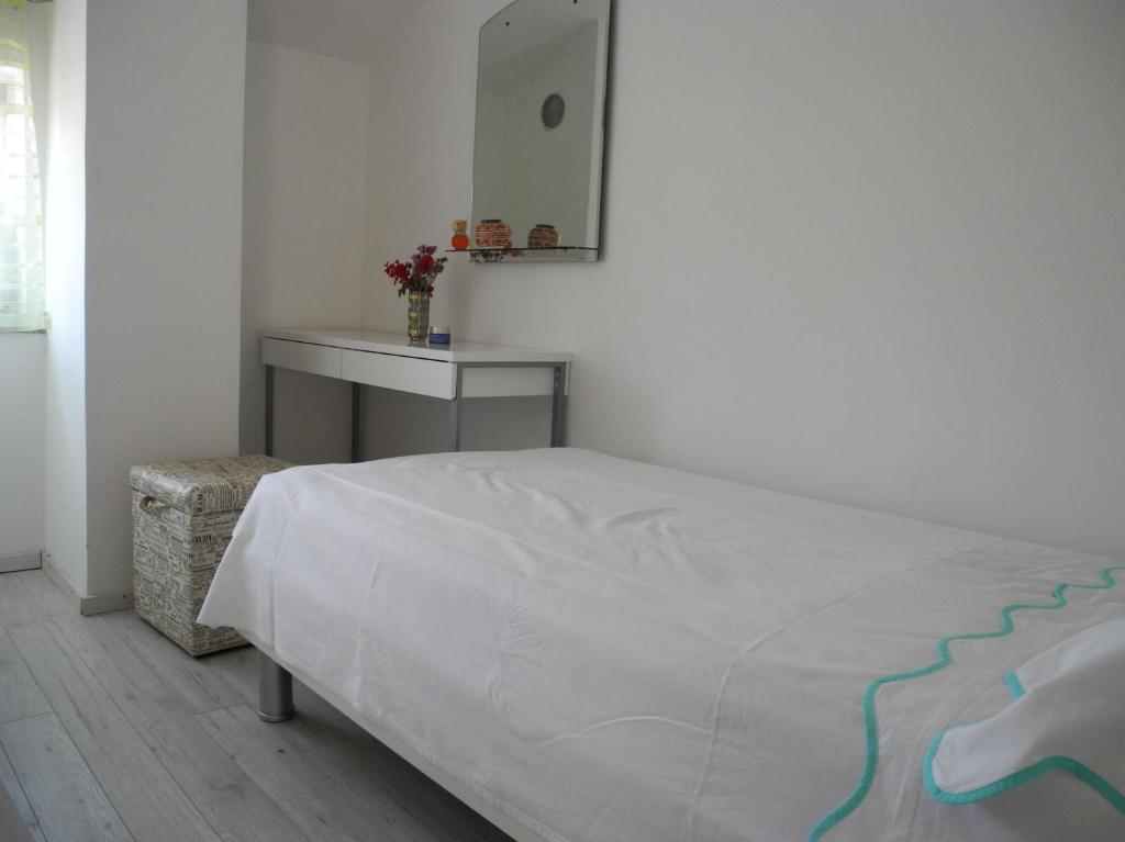 a bedroom with a bed and a table and a mirror at Villa Ines in Jezera