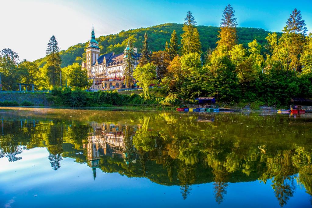 a large building on the shore of a lake at Hotel Palota Lillafured in Lillafüred