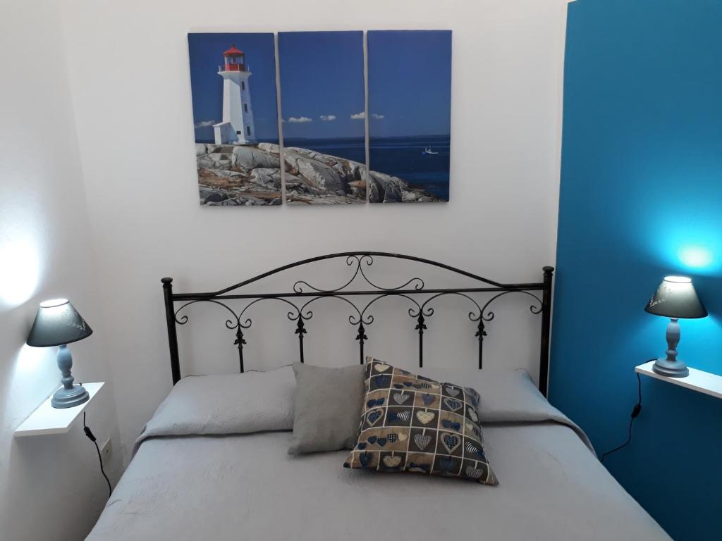 um quarto com uma cama com um farol ao fundo em Cortile Maggiore Home em Cefalù