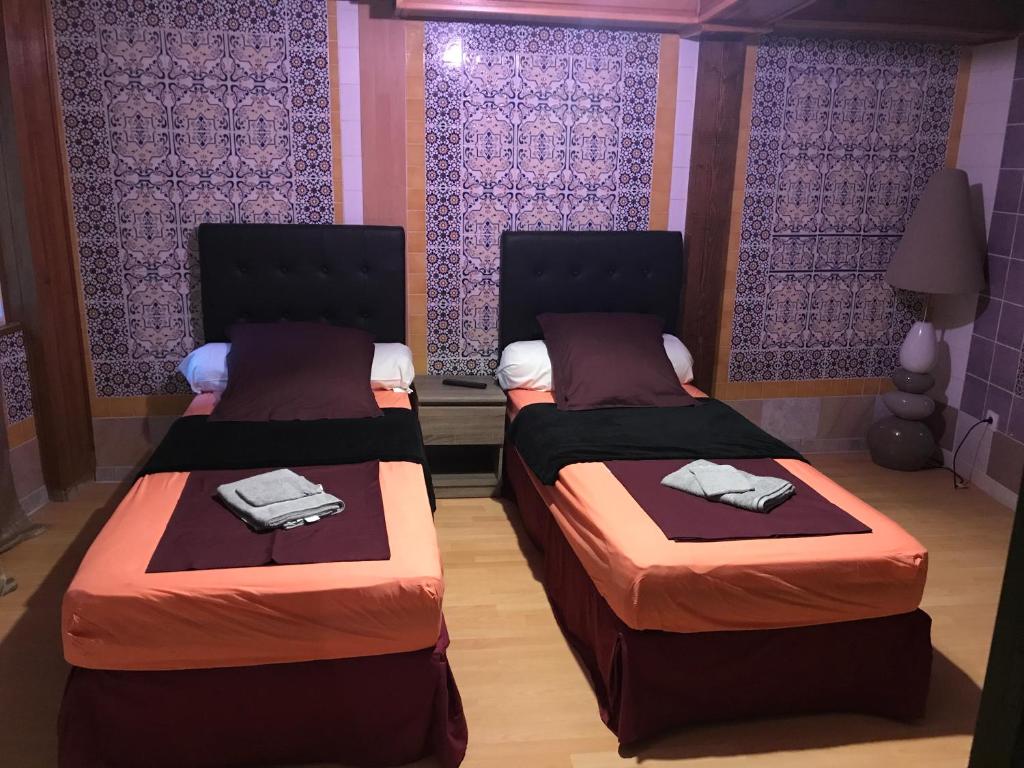 2 camas individuais num quarto com paredes roxas em Gite *Anzi* em Arcis-sur-Aube