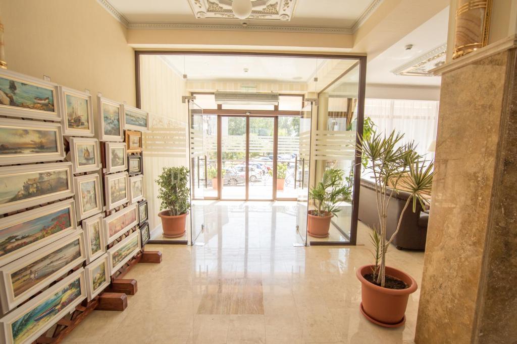 a hallway with paintings and plants in a building at MSR Port Hotel in Mangalia