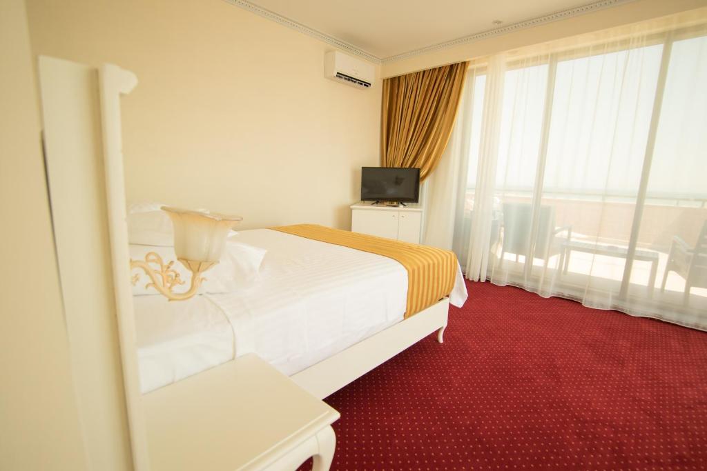 a hotel room with a bed and a television at MSR Port Hotel in Mangalia