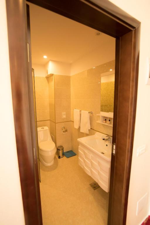 a bathroom with a toilet and a tub and a sink at MSR Port Hotel in Mangalia