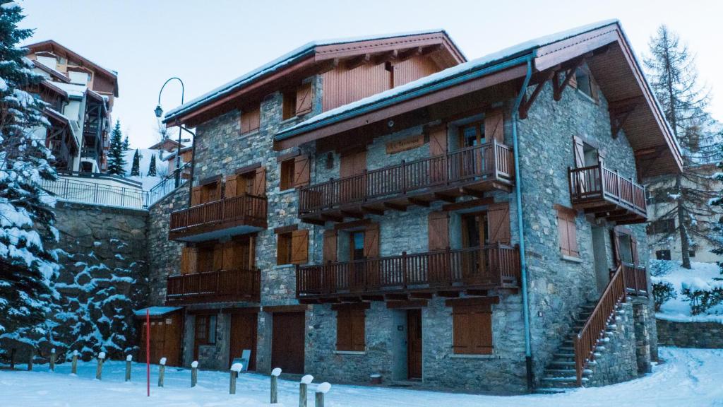 a building with balconies on the side of it in the snow at Chalet Renouveau in Saint-Martin-de-Belleville