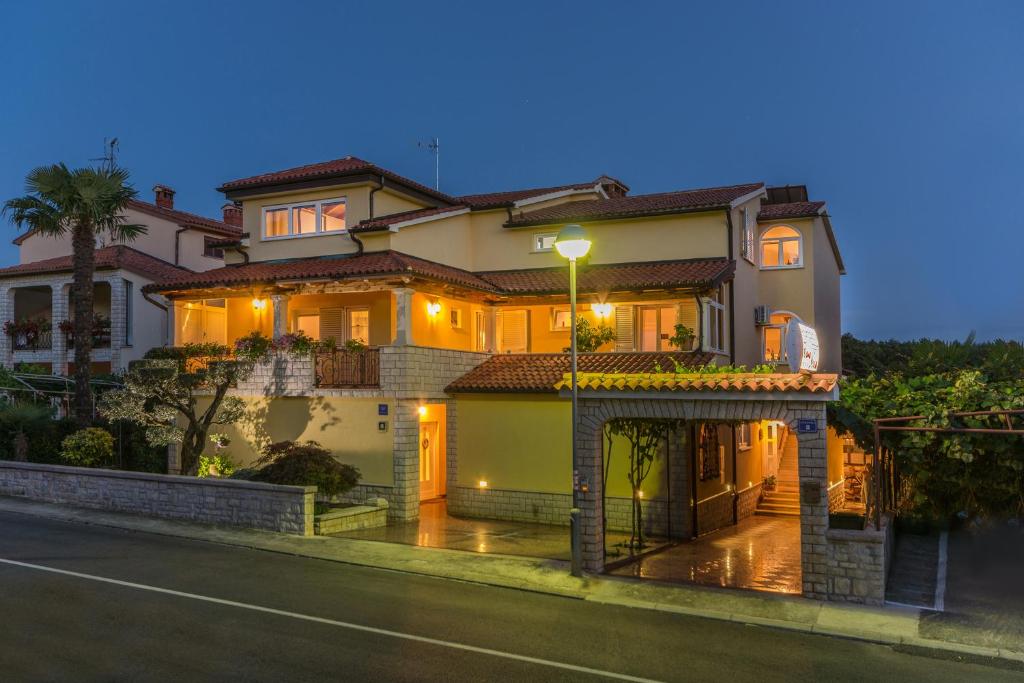 a house with a street light in front of it at Guesthouse Casa Nova in Poreč