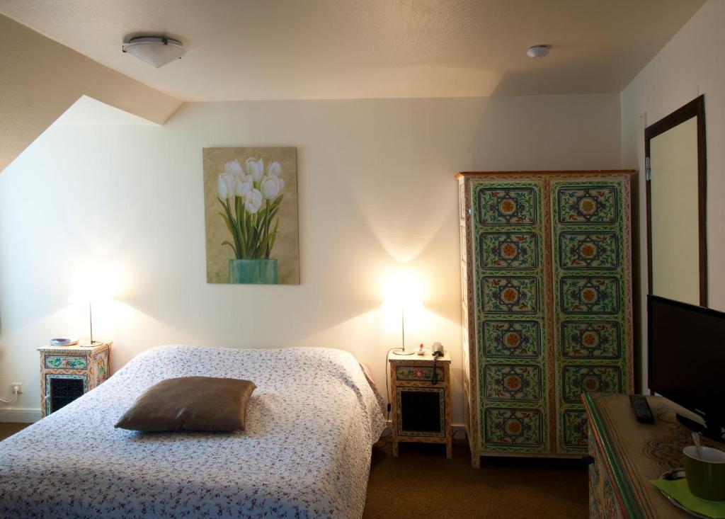 a bedroom with a bed and two lamps and a door at Hotel De Pastorij in Leuven