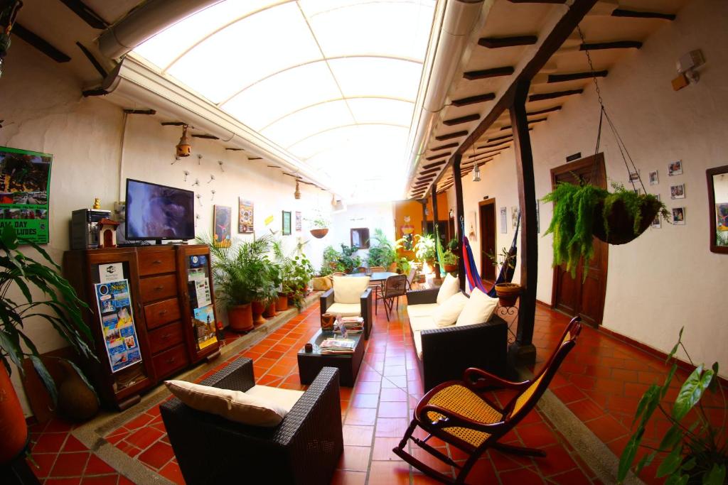 a living room with couches and chairs and a ceiling at Posada Bacaregua in San Gil