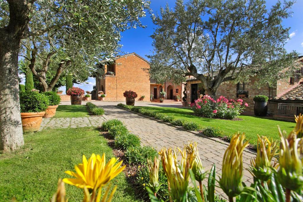 a brick walkway in front of a house with flowers at Borgo Tre Rose in Valiano