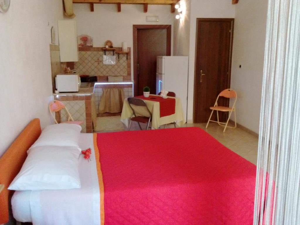 um quarto com uma cama grande e um cobertor vermelho em Relax Room em Mazara del Vallo
