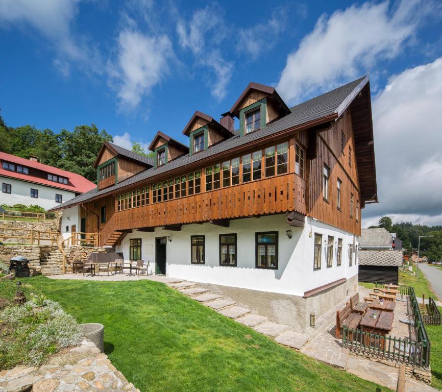 an exterior view of a large house with a yard at Wellness Hotel Florián České Žleby in Stožec