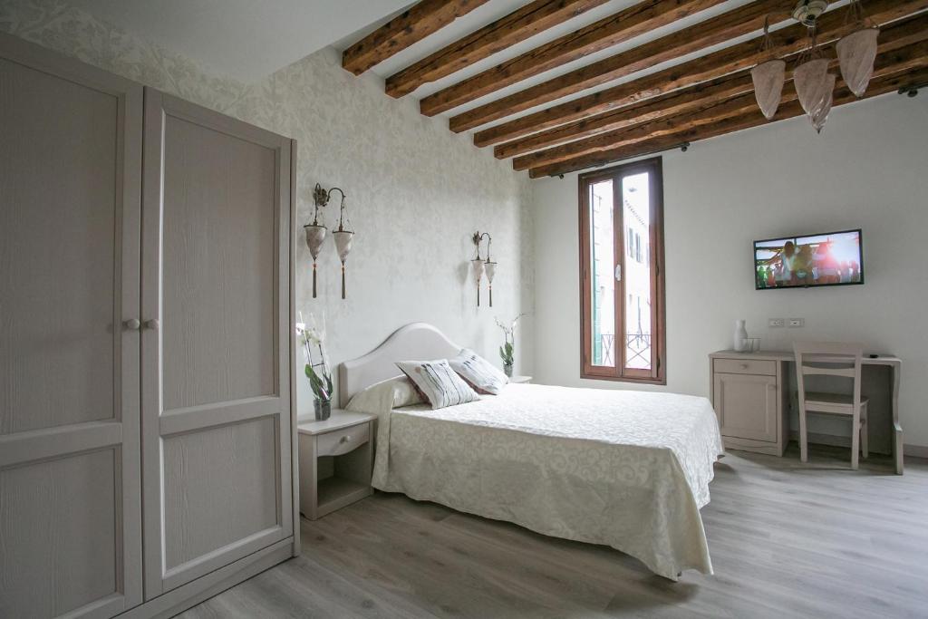 a white bedroom with a bed and a window at Guest House Ca' dell'Angelo in Venice