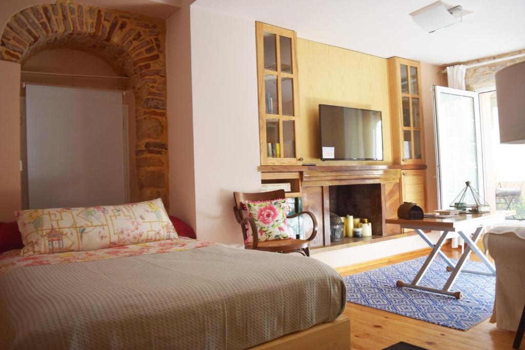 a bedroom with a bed and a desk and a television at Mastixi in Chios