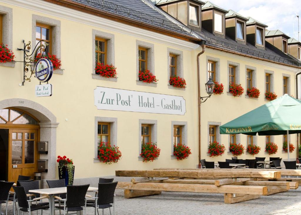 ein Gebäude mit Tischen und Stühlen davor in der Unterkunft Hotel Gasthof zur Post in Bärnau