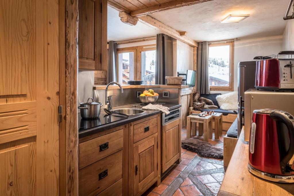a kitchen with wooden cabinets and a sink and a refrigerator at Agate in Mâcot La Plagne