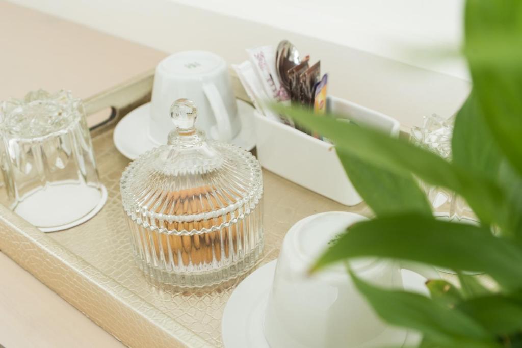 a glass bird cage sitting on a table with a plant at Castello Boutique Rooms in Kavála