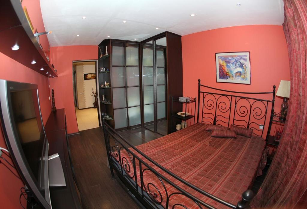 a bedroom with a large bed with red walls at Аксакова,72 Трехкомнатные апартаменты in Ufa