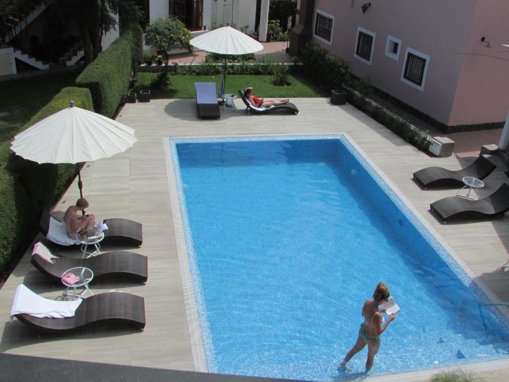 una mujer parada frente a una piscina en Queen's Villa Hotel Boutique, en Arequipa