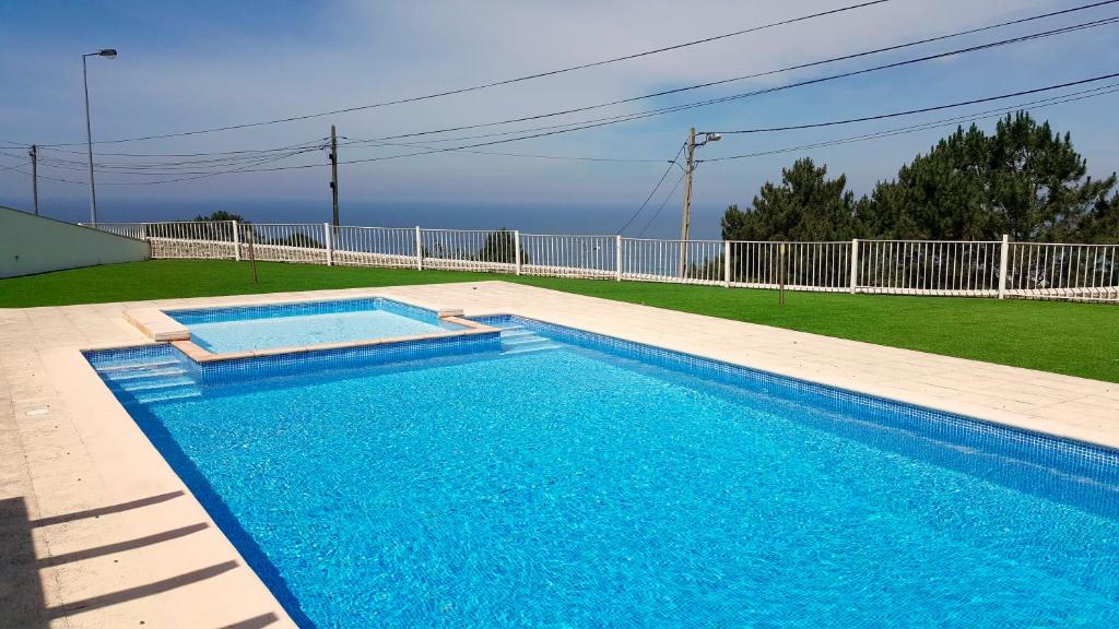 a swimming pool with blue water in a yard at JDLourenço house in Nazaré