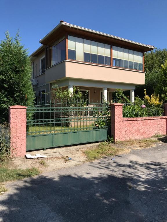 a house with a green gate in front of it at Villa 18 Kirkpinar in Sakarya