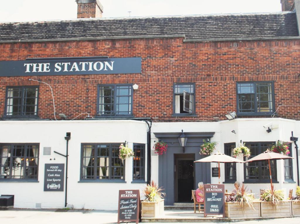 un edificio de ladrillo con un cartel que lee la estación en The Station en West Byfleet