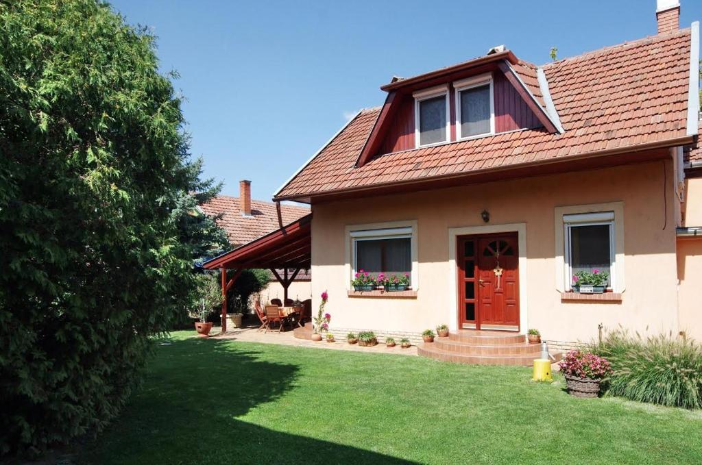 una casa con una puerta roja y un patio en Erika Apartmanház, en Gyula