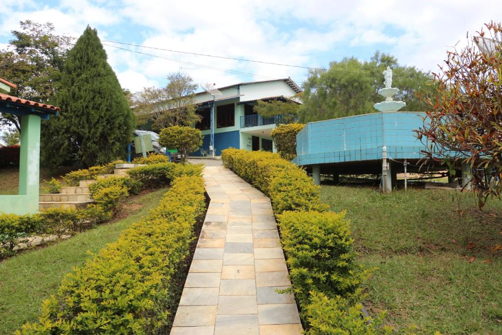 a garden with a walkway in front of a house at Estância Bela Vida in Carmo do Rio Claro