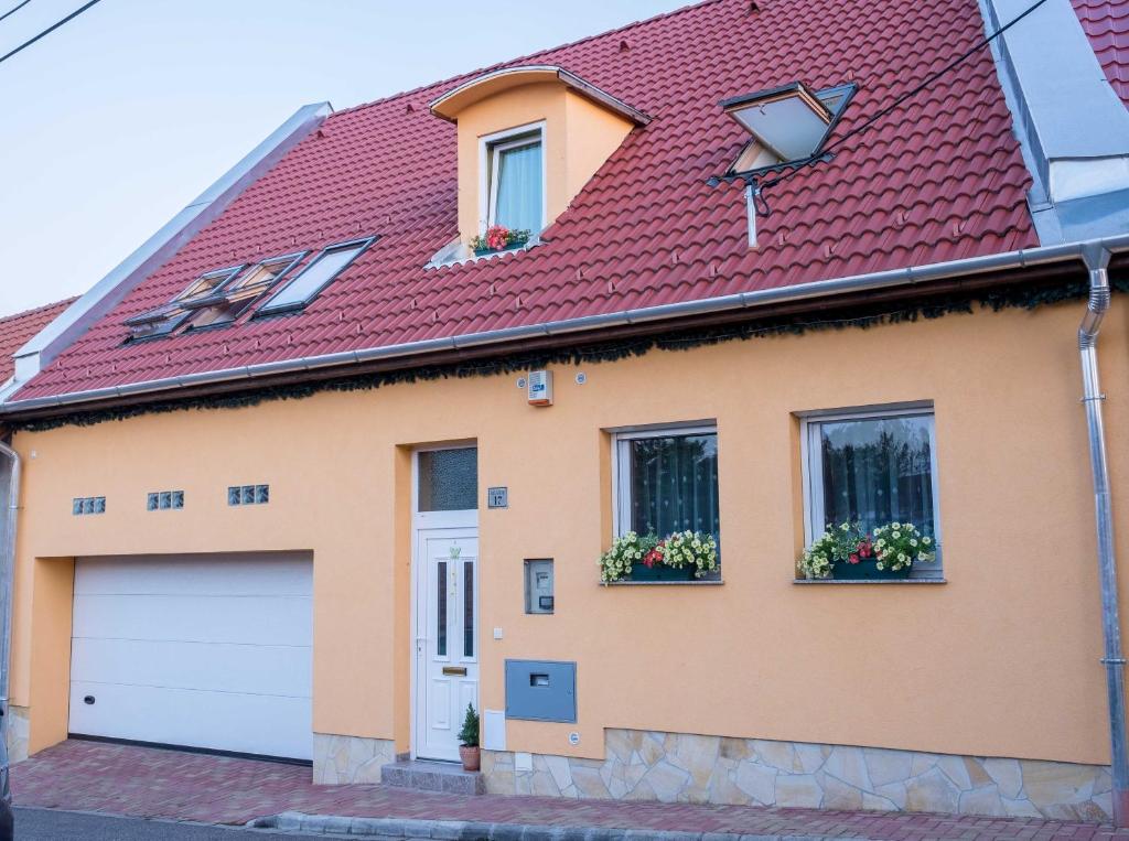 una casa con techo rojo y garaje en Sasvár Apartman en Eger