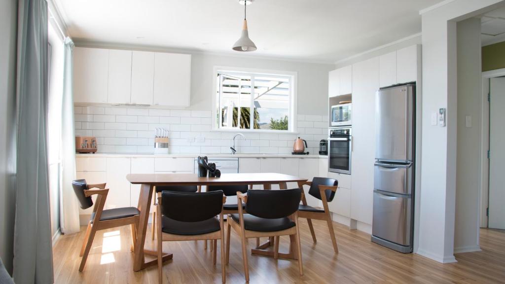 a kitchen with a table and chairs and a refrigerator at Rotorua beauty in Rotorua