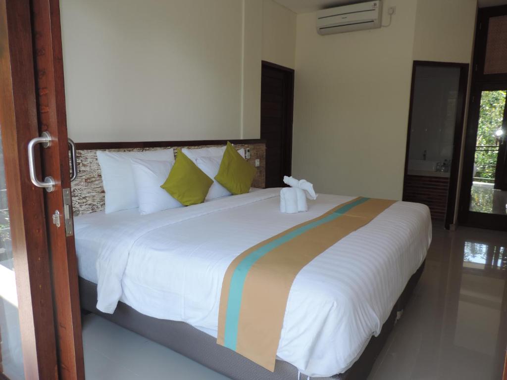 Postel nebo postele na pokoji v ubytování Kencana Ubud by Mahaputra