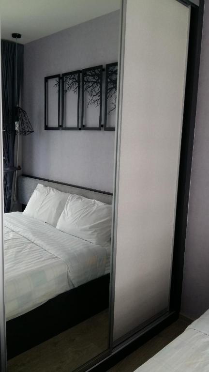 a mirror in front of a bedroom with a bed at The BASE Central Pattaya by NKL in Pattaya Central