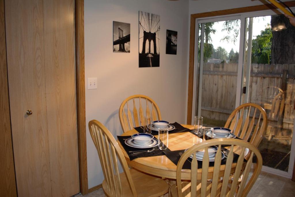 einen Esstisch mit Stühlen und einem Holztisch sowie einem Tisch und einem Chairsktop in der Unterkunft 8635 Ustick Road Apartment in Boise