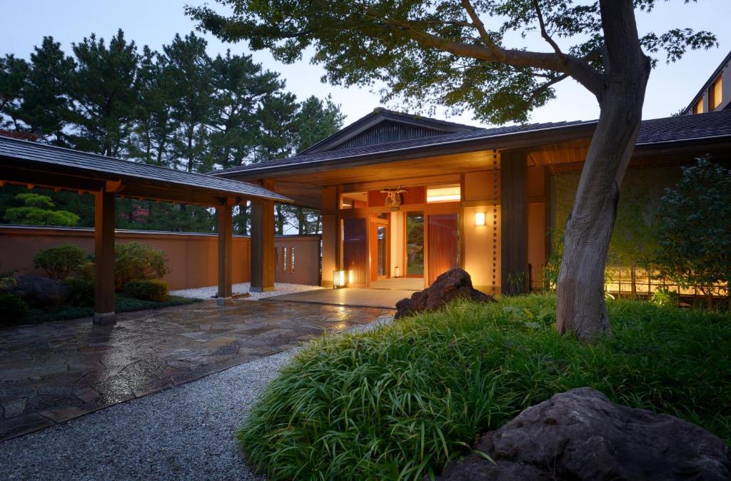 a house with a tree in front of it at Toba International Hotel Shiojitei in Toba