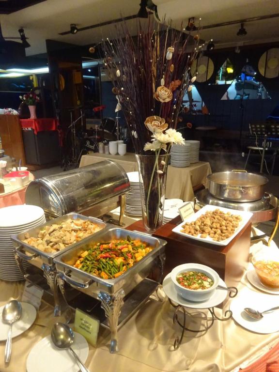 A buffet station with hot trays, a covered dish and dipping condiments.