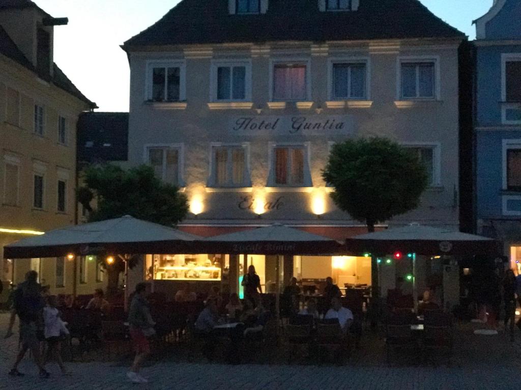 
people sitting at tables outside of a restaurant at Hotel Guntia in Günzburg
